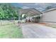 Exterior view showcasing the house with a metal carport on a gravel drive, fenced yard, and landscaping at 119 Marietta Rd, Mooresville, NC 28117