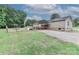Wide shot of a house featuring a metal carport, gravel driveway and a spacious yard with tree line at 119 Marietta Rd, Mooresville, NC 28117