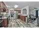 Open kitchen with stainless appliances, wooden cabinets, and hardwood floors, leading to living room at 119 Marietta Rd, Mooresville, NC 28117