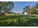 View of a large, verdant backyard with a white shed and plenty of space to play at 136 Wood Duck Loop, Mooresville, NC 28117