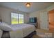 Bedroom featuring a large window with blinds, neutral walls, and a comfortable queen bed at 136 Wood Duck Loop, Mooresville, NC 28117