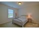 Bedroom featuring a metal frame bed with side table and a window for natural light at 136 Wood Duck Loop, Mooresville, NC 28117