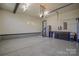 View of the spacious garage with epoxy floor, tool storage, and a refrigerator at 136 Wood Duck Loop, Mooresville, NC 28117
