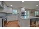 Modern kitchen with a spacious island, white cabinets, and stainless steel appliances at 136 Wood Duck Loop, Mooresville, NC 28117