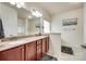 Elegant bathroom featuring dual sinks, granite counters, dark wood cabinets, and a large mirror at 14113 Highland Meadow Rd, Charlotte, NC 28273