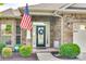 Home's inviting front porch, showcasing a brick facade, decorative wreath, and well-maintained landscaping at 14113 Highland Meadow Rd, Charlotte, NC 28273