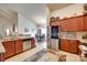 Bright kitchen features stainless steel refrigerator, wood cabinets, granite counters, and a view into the dining room at 14113 Highland Meadow Rd, Charlotte, NC 28273