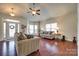 Bright living room features hardwood flooring, neutral-toned sofas, and abundant natural light from large windows at 14113 Highland Meadow Rd, Charlotte, NC 28273