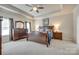 Spacious main bedroom with a wooden bed, dresser, and nightstands under a tray ceiling at 14113 Highland Meadow Rd, Charlotte, NC 28273