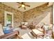 Relaxing sunroom with brick accent wall and wicker furniture, creating a cozy retreat at 14113 Highland Meadow Rd, Charlotte, NC 28273