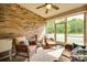 Relaxing sunroom with brick accent wall, wicker furniture, and a view of the outdoors at 14113 Highland Meadow Rd, Charlotte, NC 28273
