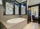 A luxurious bathroom showcasing a modern soaking tub, stylish finishes, and a serene atmosphere at 1413 Devon Dr, Charlotte, NC 28209