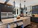 Modern kitchen with dark cabinets, stainless steel appliances, and a large island with seating at 1413 Devon Dr, Charlotte, NC 28209