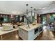 Open kitchen featuring a large island with a sink, stainless appliances, and an open view to the living room at 1413 Devon Dr, Charlotte, NC 28209