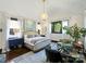 Spacious main bedroom featuring stylish decor, hardwood floors, sitting area, natural light, and an elegant chandelier at 1413 Devon Dr, Charlotte, NC 28209