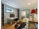 Home office with modern desk, built-in shelves, and view into another room with seating at 1413 Devon Dr, Charlotte, NC 28209