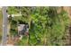 Aerial view of backyard with wooden deck, surrounded by mature trees and lush green landscaping at 15324 Yarmouth Rd, Mint Hill, NC 28227