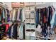 Organized walk-in closet with hanging racks, shelves, and compartments for clothing and accessories at 15324 Yarmouth Rd, Mint Hill, NC 28227
