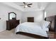 Comfortable bedroom with a tray ceiling, ceiling fan, and dark wooden furniture at 15324 Yarmouth Rd, Mint Hill, NC 28227