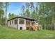 Charming single-story home features a large, covered wooden deck and lush green lawn surrounded by mature trees at 1534 Easy St, Belmont, NC 28012