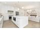 Well-lit kitchen boasts white cabinetry, stainless steel appliances, and an island with a breakfast bar at 1534 Easy St, Belmont, NC 28012