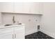 Modern laundry room with sleek cabinetry, stainless steel sink, and chic hexagonal tile floor at 1534 Easy St, Belmont, NC 28012