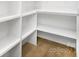 Open pantry with wood floors and built in custom shelving offering ample storage space at 1534 Easy St, Belmont, NC 28012
