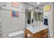 Bathroom showcasing a single sink vanity, toilet, and large mirror at 1832 J Julian Ln, Charlotte, NC 28208