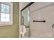 Bathroom featuring a glass-enclosed shower with dark hardware and a bright window at 1904 Lynnwood Dr, Charlotte, NC 28209