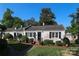 Charming, whitewashed brick home with manicured landscaping, black shutters, and a cozy front porch at 1904 Lynnwood Dr, Charlotte, NC 28209