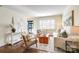 Bright living room featuring hardwood floors, neutral decor, plantation shutters, and a stylish rug at 1904 Lynnwood Dr, Charlotte, NC 28209