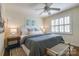 Comfortable bedroom features a ceiling fan, plush bedding, and two windows for natural light at 1904 Lynnwood Dr, Charlotte, NC 28209