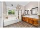 Bright bathroom with a large soaking tub, glass shower, and double vanity sinks at 1916 Pine Mountain Rd, Charlotte, NC 28214
