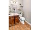 Charming powder room with tile floors, a wood vanity, a white toilet, and minimalist decor at 1916 Pine Mountain Rd, Charlotte, NC 28214