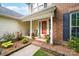 Inviting front porch with an orange door, flowers, and chairs at 1916 Pine Mountain Rd, Charlotte, NC 28214