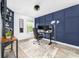 Modern home office featuring blue accent wall, desk, chair, and built-in shelving at 1916 Pine Mountain Rd, Charlotte, NC 28214