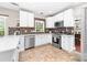 Well-lit kitchen with stainless steel appliances, white cabinets, and tiled backsplash at 1916 Pine Mountain Rd, Charlotte, NC 28214