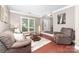 Inviting living room with wood floors, a comfortable sofa, decorative pillows, and a large window offering natural light at 1916 Pine Mountain Rd, Charlotte, NC 28214