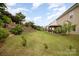 Large backyard features mature landscaping, a charming gazebo, brick retaining wall, and a spacious green lawn at 2041 Topaz Plz, Davidson, NC 28036