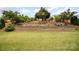 Landscaped backyard with a brick retaining wall, various plants and greenery, and a well-manicured lawn at 2041 Topaz Plz, Davidson, NC 28036