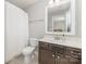 This bathroom showcases a white vanity with a dark brown cabinet and a decorative mirror at 2041 Topaz Plz, Davidson, NC 28036
