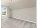 This bonus room features neutral walls, carpeted floors, and a window providing natural light at 2041 Topaz Plz, Davidson, NC 28036