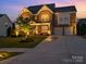 Beautiful home with a stone and siding exterior, well-lit yard, and a spacious driveway leading to a two-car garage at 2041 Topaz Plz, Davidson, NC 28036