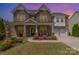 Stately brick home with lush landscaping, a welcoming front porch, and a three-car garage, showcasing curb appeal at 2041 Topaz Plz, Davidson, NC 28036