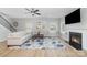 Cozy living room with fireplace, ceiling fan, neutral furnishings, large windows, and hardwood floors at 2041 Topaz Plz, Davidson, NC 28036