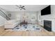 Cozy living room includes a fireplace, ceiling fan, neutral furnishings, and multiple bright windows at 2041 Topaz Plz, Davidson, NC 28036