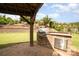 Outdoor kitchen with a built-in grill and brick facade, ideal for entertaining in a beautifully landscaped yard at 2041 Topaz Plz, Davidson, NC 28036