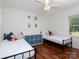 Cozy bedroom with two twin beds, hardwood floors and lots of natural light from the large window at 2054 Hickory Hills Dr, Denver, NC 28037
