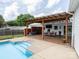 An outdoor living space with covered deck with table and chairs overlooking the refreshing in-ground pool at 2054 Hickory Hills Dr, Denver, NC 28037