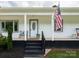 Inviting front porch with black brick base, rocking chairs, and a U.S. flag at 2054 Hickory Hills Dr, Denver, NC 28037